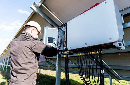 Juruteknik memeriksa inverter dan sistem elektrik panel solar rumah