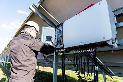 Solar technician inspecting inverter performance during a residential solar installation