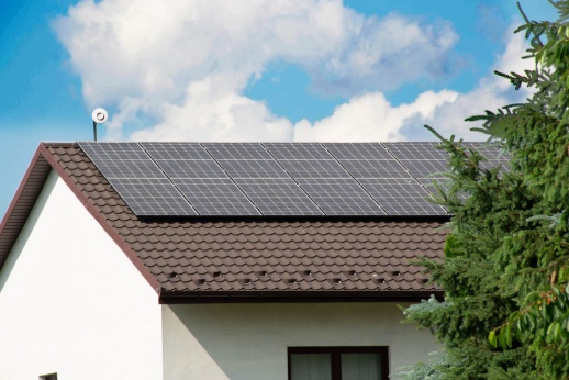 Solar technician installing rooftop solar panels for a residential home