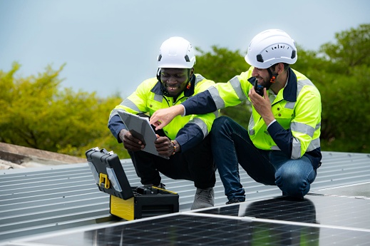 Solar technicians inspecting and testing a residential solar panel system 

