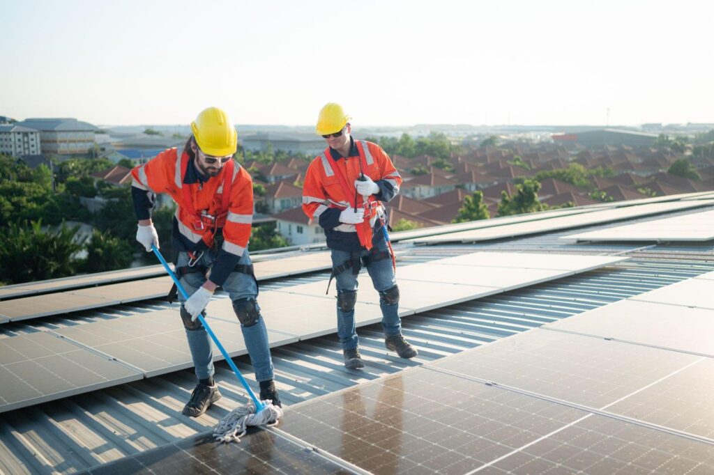 Solar technicians inspecting rooftop solar panels on a commercial building